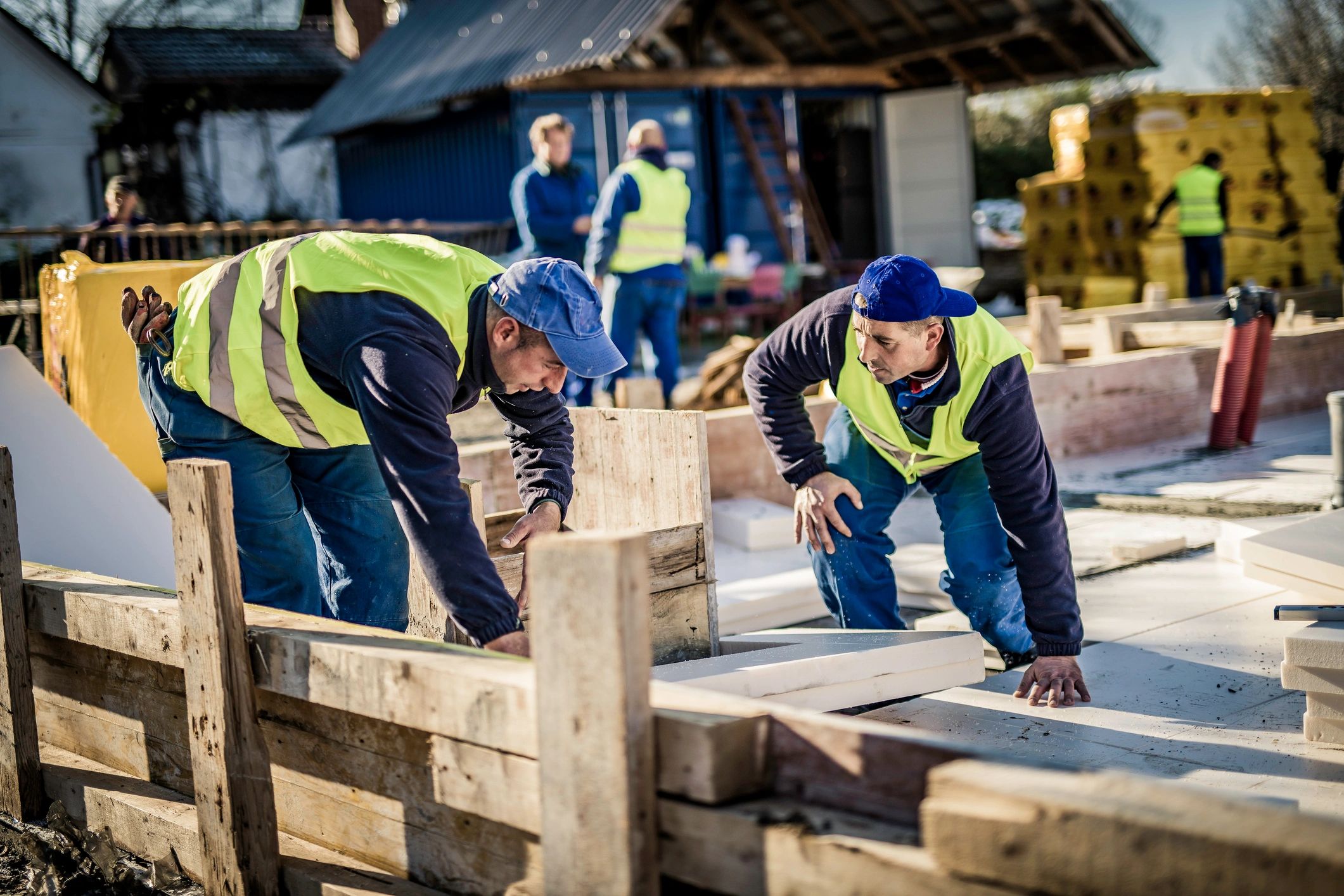Workers installing flooring insulation in a new home
