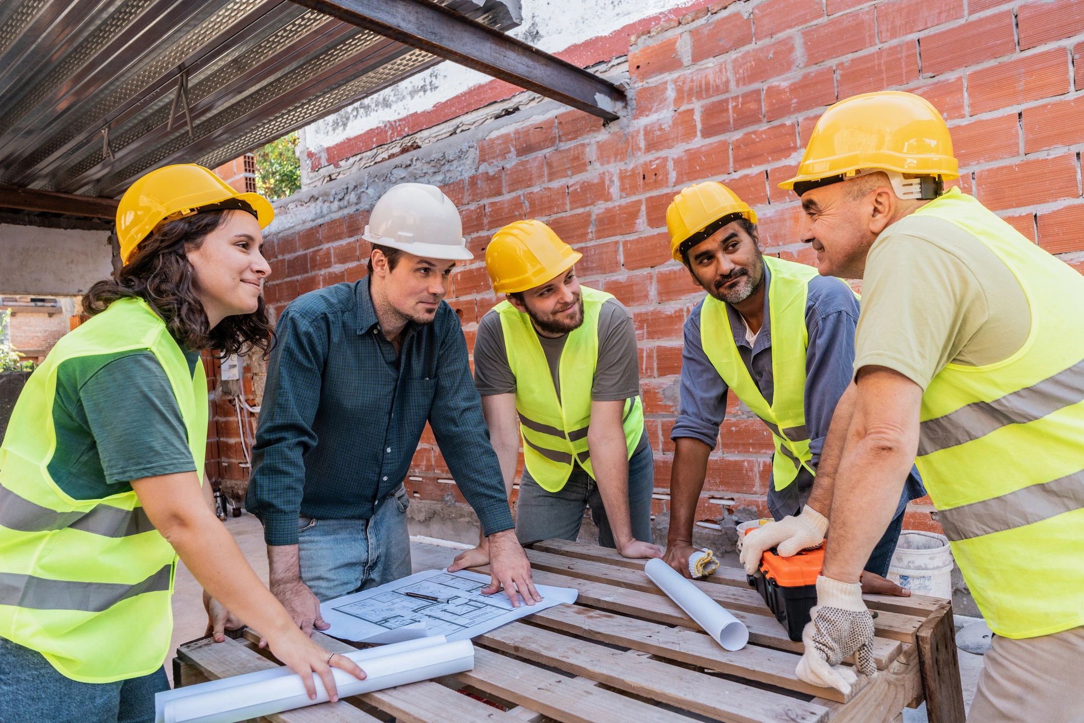 Construction professional speaking with workers on site