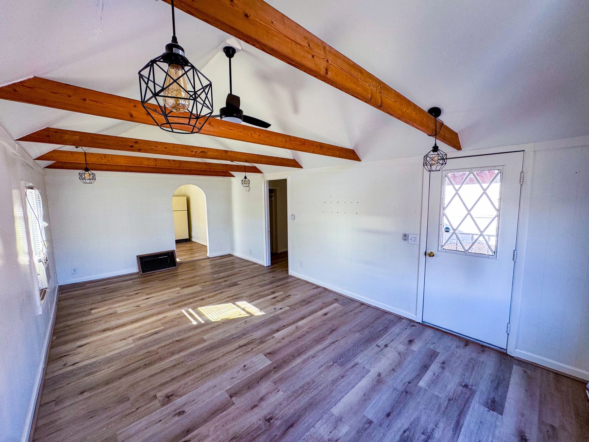 Finished living room space with wood beams and natural light